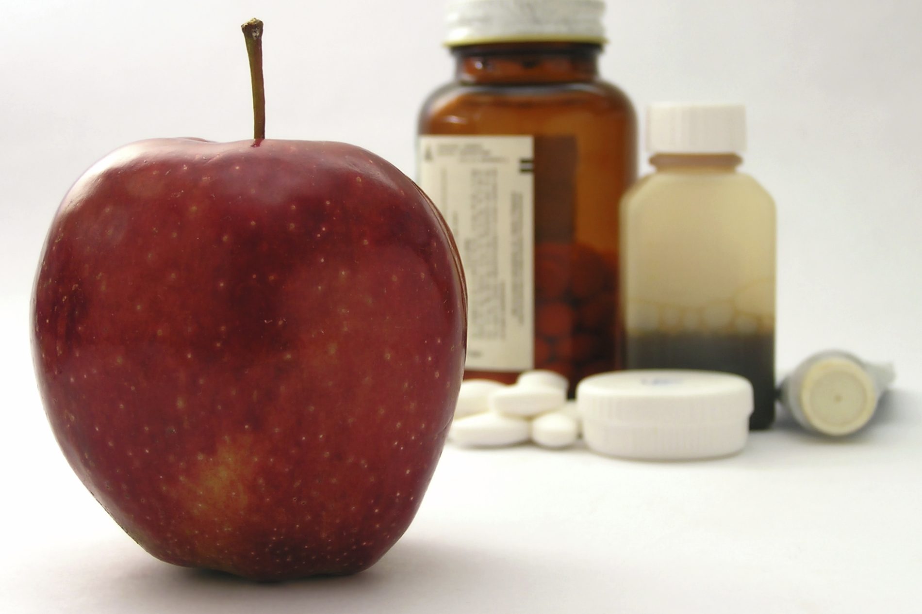 Apfel und Medikamente im Hintergrund